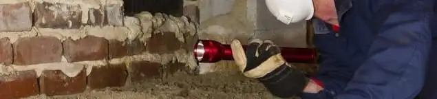 Pest control technician inspecting a crawl space for ant activity and entry points in Overland Park, KS