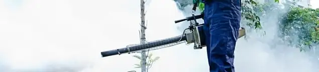 Pest control technician fogging an outdoor area for insect control in Overland Park, KS