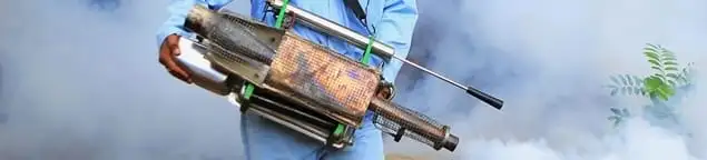 Fumigation technician using a fogger for deep pest treatment in Overland Park, KS