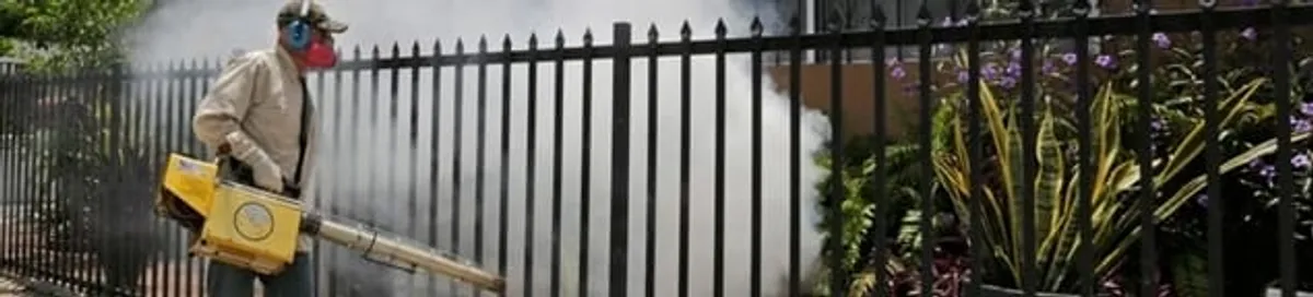 Mosquito control technician fogging a yard perimeter for mosquito reduction in Overland Park, KS